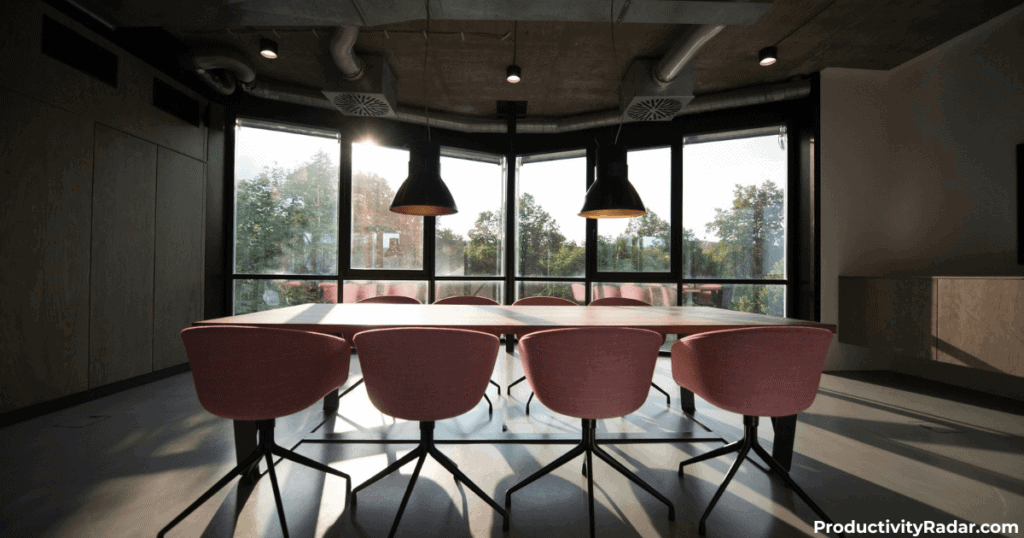 Industrial-style meeting room with pendant lights and pink chairs - Microsoft Copilot for managers review
