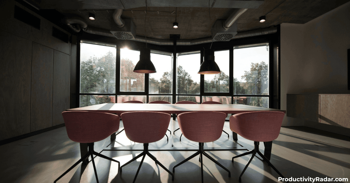 Industrial-style meeting room with pendant lights and pink chairs - ChatGPT for self-evaluations